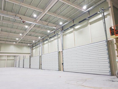 Puertas seccionales industriales de almacén Puertas seccionales comerciales automáticas de acero